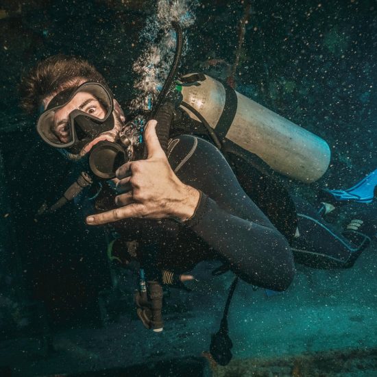 scuba diver exploring inside a military shipwreck